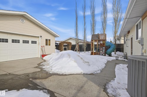 Snowy yard featuring a playground, a garage, and an outdoor structure - 4204 41B Street, Leduc, AB - Outdoor