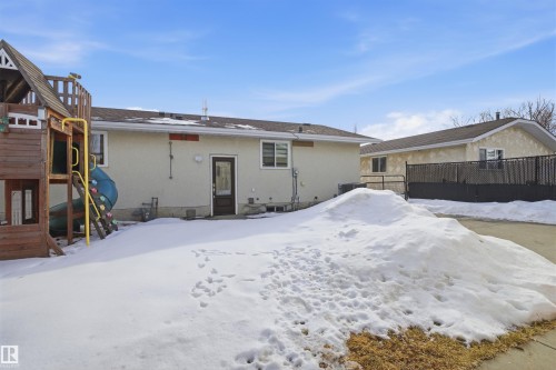 Snow covered rear of property with stucco siding and a playground - 4204 41B Street, Leduc, AB - Outdoor
