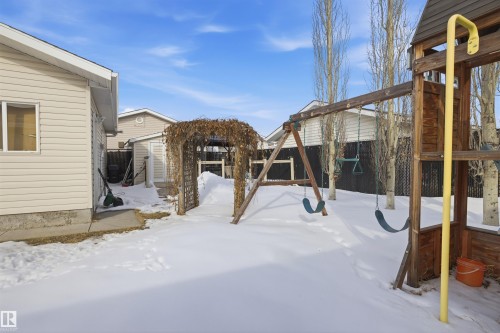 Yard covered in snow featuring a playground, a fenced backyard, and a shed - 4204 41B Street, Leduc, AB - Outdoor