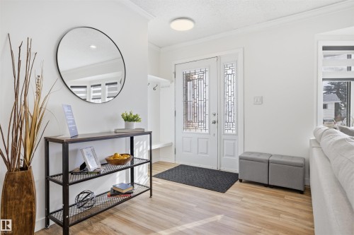 Entryway featuring crown molding, light wood-type flooring, plenty of natural light, and a textured ceiling - 4204 41B Street, Leduc, AB - Indoor Photo Showing Other Room