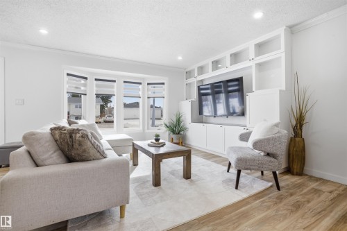 Living area featuring light wood-style floors, a textured ceiling, ornamental molding, and recessed lighting - 4204 41B Street, Leduc, AB - Indoor Photo Showing Living Room