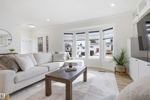 Living area with light wood finished floors, ornamental molding, and recessed lighting - 4204 41B Street, Leduc, AB - Indoor Photo Showing Living Room