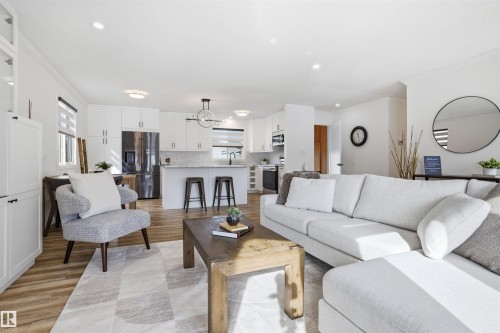 Living room featuring light wood-style floors, crown molding, plenty of natural light, and a chandelier - 4204 41B Street, Leduc, AB - Indoor Photo Showing Living Room