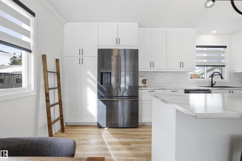 Kitchen with refrigerator with ice dispenser, white cabinets, tasteful backsplash, light wood-style flooring, and recessed lighting - 4204 41B Street, Leduc, AB - Indoor Photo Showing Kitchen With Upgraded Kitchen