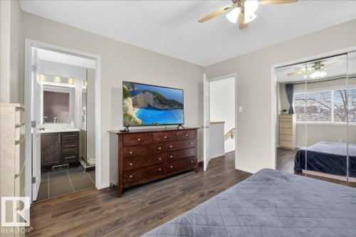 Bedroom with dark wood-style floors, a closet, a textured ceiling, a ceiling fan, and ensuite bathroom - 4519 Turner Square Square, Edmonton, AB - Indoor Photo Showing Bedroom