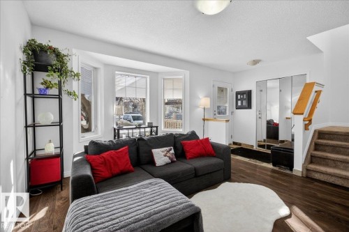 Living area featuring dark wood-type flooring and a textured ceiling - 4519 Turner Square Square, Edmonton, AB - Indoor Photo Showing Living Room