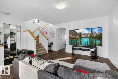 Living area featuring arched walkways, dark wood finished floors, and a textured ceiling - 4519 Turner Square Square, Edmonton, AB - Indoor Photo Showing Living Room