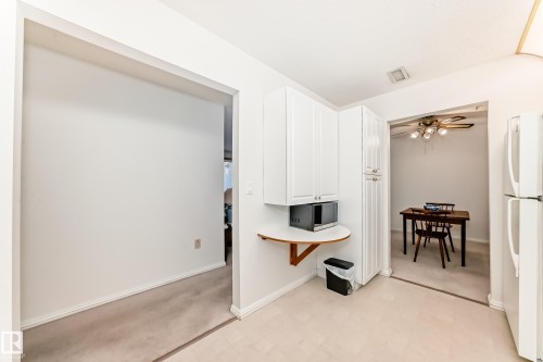 Kitchen featuring light floors, freestanding refrigerator, white cabinets, stainless steel microwave, and a ceiling fan - 118 6220 Fulton Road, Edmonton, AB - Indoor Photo Showing Other Room