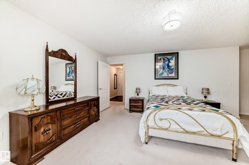 Bedroom with light colored carpet and a textured ceiling - 118 6220 Fulton Road, Edmonton, AB - Indoor Photo Showing Bedroom