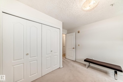 Unfurnished bedroom with light carpet, a textured ceiling, and a closet - 118 6220 Fulton Road, Edmonton, AB - Indoor Photo Showing Other Room