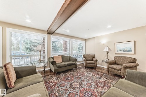 Common area with wood finished floors, beamed ceiling, and recessed lighting - 118 6220 Fulton Road, Edmonton, AB - Indoor Photo Showing Living Room