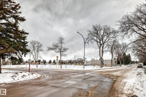 View of asphalt road with traffic signs and street lighting - 118 6220 Fulton Road, Edmonton, AB - Outdoor With View