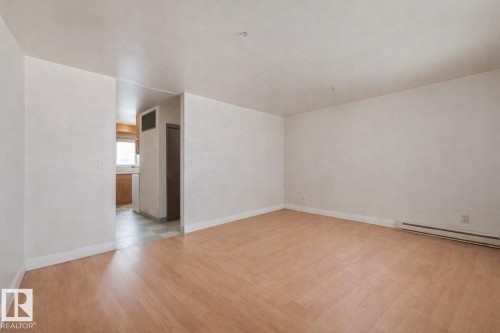 Spare room with light wood-type flooring and a baseboard radiator - 5219 51 Avenue, Wetaskiwin, AB - Indoor Photo Showing Other Room