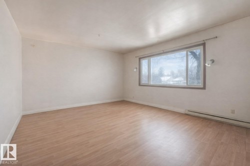 Unfurnished room with light wood finished floors and baseboard heating - 5219 51 Avenue, Wetaskiwin, AB - Indoor Photo Showing Other Room