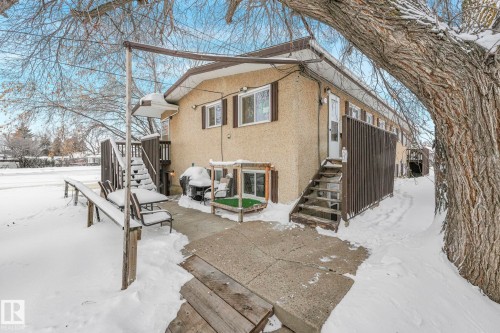 View of snowy exterior with stucco siding and a deck - 5219 51 Avenue, Wetaskiwin, AB - Outdoor
