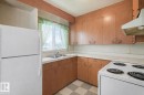 Kitchen featuring white appliances, light flooring, light countertops, and wood finish cabinets - 5219 51 Avenue, Wetaskiwin, AB  - Indoor Photo Showing Kitchen With Double Sink 