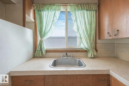 Kitchen with light countertops and wood finish cabinetry - 5219 51 Avenue, Wetaskiwin, AB - Indoor Photo Showing Kitchen