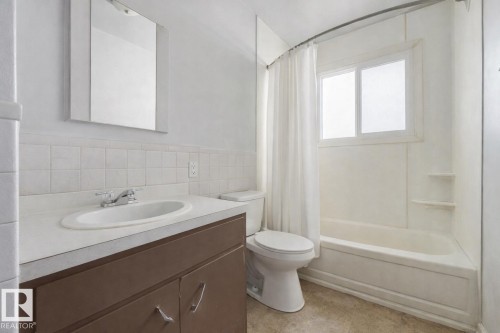 Full bath featuring vanity, shower / tub combo, and tile walls - 5219 51 Avenue, Wetaskiwin, AB - Indoor Photo Showing Bathroom
