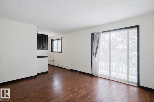 Empty room with a textured ceiling and dark wood-style floors - 3917/3919 54 Street, Wetaskiwin, AB - Indoor Photo Showing Other Room