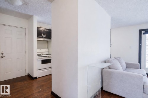 Hall with a textured ceiling and dark wood-style flooring - 3917/3919 54 Street, Wetaskiwin, AB - Indoor