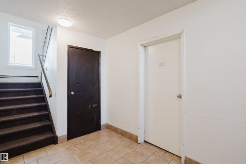 Entrance foyer with a textured ceiling and light tile patterned floors - 3917/3919 54 Street, Wetaskiwin, AB - Indoor Photo Showing Other Room