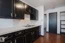 Kitchen with dark cabinetry, dark wood finished floors, light countertops, a textured ceiling, and tasteful backsplash - 3917/3919 54 Street, Wetaskiwin, AB  - Indoor Photo Showing Kitchen With Double Sink 