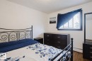 Bedroom with a textured ceiling, dark wood-type flooring, and a baseboard heating unit - 3917/3919 54 Street, Wetaskiwin, AB  - Indoor Photo Showing Bedroom 