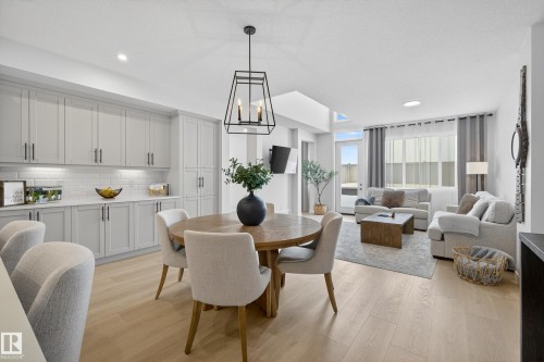 Dining area with light wood-style floors and suspended lighting - 19286 22A Avenue, Edmonton, AB 