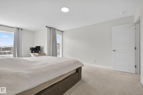 Bedroom with light carpet and multiple windows - 19286 22A Avenue, Edmonton, AB 