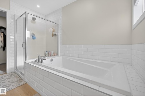 Bathroom featuring a bath, a shower stall, and a spacious closet - 19286 22A Avenue, Edmonton, AB 