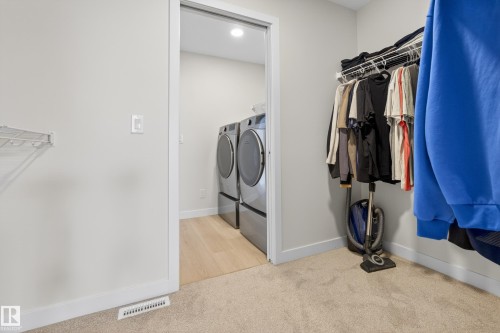Laundry room with light colored carpet, independent washer and dryer, and recessed lighting - 19286 22A Avenue, Edmonton, AB 