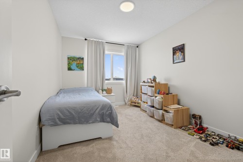 Bedroom featuring light colored carpet and a textured ceiling - 19286 22A Avenue, Edmonton, AB 