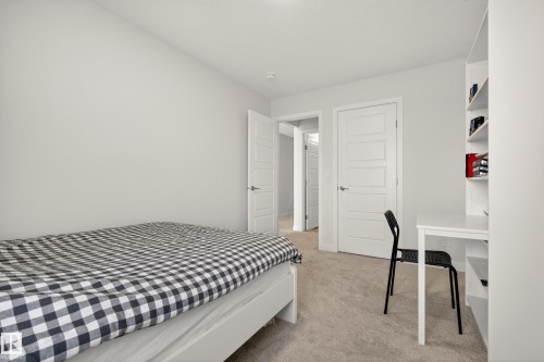 Bedroom with light carpet and an office area - 19286 22A Avenue, Edmonton, AB 