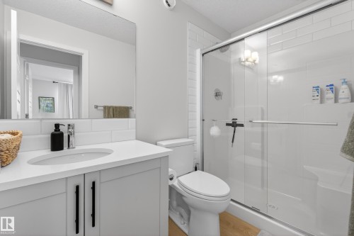 Bathroom featuring vanity, a stall shower, and light wood-style floors - 19286 22A Avenue, Edmonton, AB 
