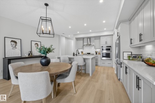 Dining space with light wood-style flooring and a chandelier - 19286 22A Avenue, Edmonton, AB 