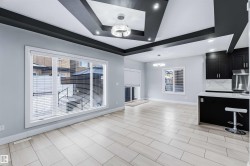 Unfurnished living room featuring a raised ceiling and a chandelier - 