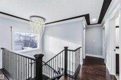 Corridor featuring dark wood-style floors, an upstairs landing, a chandelier, crown molding, and a textured ceiling - 