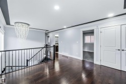 Unfurnished room featuring a chandelier, crown molding, dark wood finished floors, and recessed lighting - 