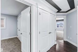 Hall with ornamental molding and dark carpet - 