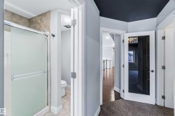 Full bathroom featuring a stall shower and toilet - 