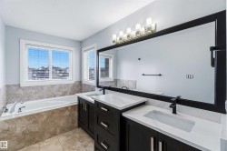 Full bath featuring double vanity, a garden tub, and light tile patterned flooring - 