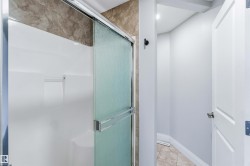 Full bath with a shower stall and light tile patterned floors - 
