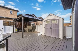 Wooden terrace with a gazebo, a shed, a fenced backyard, and an outdoor living space - 