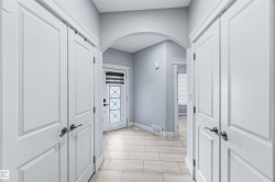 Corridor featuring arched walkways and baseboards - 