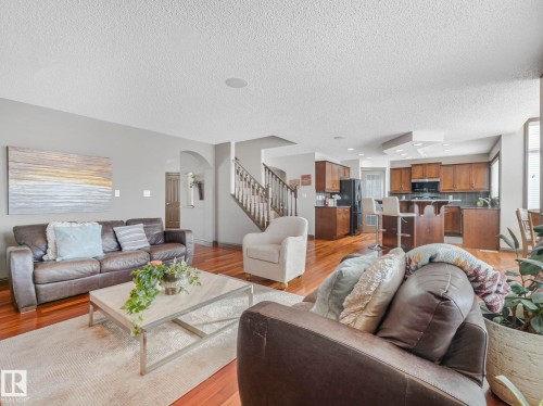 Living area featuring light wood-style floors, arched walkways, and a textured ceiling - 960 Summerside Link, Edmonton, AB - Indoor Photo Showing Living Room
