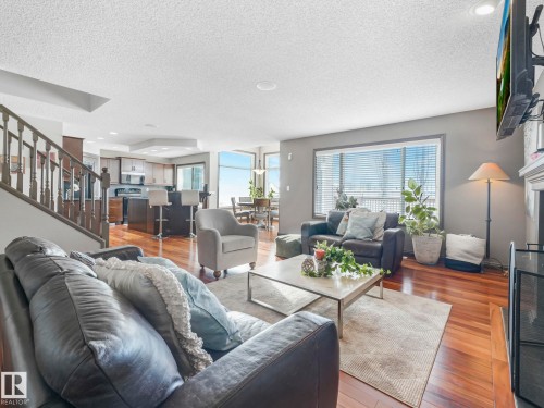 Living area featuring hardwood / wood-style floors, a textured ceiling, healthy amount of natural light, and recessed lighting - 960 Summerside Link, Edmonton, AB - Indoor Photo Showing Living Room