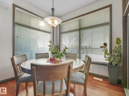 Dining area featuring a textured ceiling, wood-type flooring, and healthy amount of natural light - 960 Summerside Link, Edmonton, AB - Indoor Photo Showing Dining Room