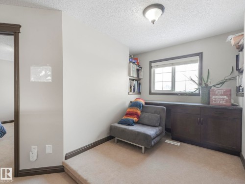 Sitting room with light carpet and a textured ceiling - 960 Summerside Link, Edmonton, AB - Indoor