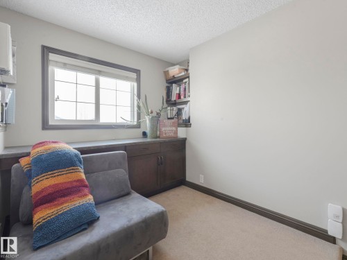 Living area with a textured ceiling and light carpet - 960 Summerside Link, Edmonton, AB - Indoor