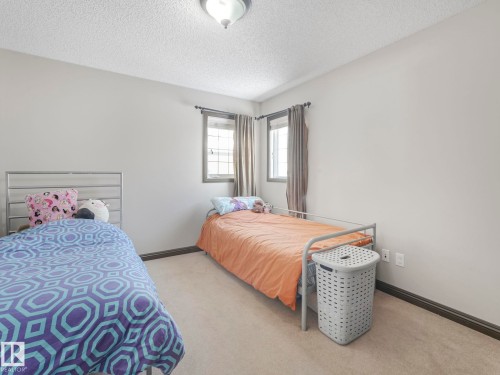 Bedroom with light carpet and a textured ceiling - 960 Summerside Link, Edmonton, AB - Indoor Photo Showing Bedroom